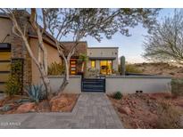 Inviting front entrance with stone accents, desert landscaping, and a secure gated entry at 15949 E Ridgestone Dr, Fountain Hills, AZ 85268