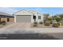 Charming single-story home featuring a neutral stucco facade, a brick driveway, and a two-car garage at 19134 W Madison St, Buckeye, AZ 85326