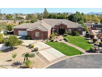 Stunning single-story red brick home with a well-manicured lawn, mature trees, and a circular driveway at 2222 N Val Vista Dr # 2, Mesa, AZ 85213
