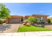 Charming home with a well-manicured lawn, desert landscaping, and an attached two-car garage at 42017 N Crooked Stick Rd, Anthem, AZ 85086
