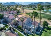 Aerial view of condo community with manicured lawns, towering palms, and a golf course backdrop at 7356 N Via Camello Del Norte -- # 208, Scottsdale, AZ 85258