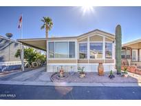Charming single-story manufactured home featuring low-maintenance landscaping and a convenient covered parking area at 7750 E Broadway Rd # 906, Mesa, AZ 85208