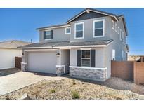 Charming two-story home featuring stone accents, neutral paint, an attached two-car garage and a low maintenance front yard at 9036 S 196Th Dr, Goodyear, AZ 85338