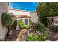 Charming courtyard with tile flooring, lush landscaping, and a cozy covered area with beautiful columns at 9478 N 105Th St, Scottsdale, AZ 85258