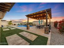 Outdoor patio with pergola, dining area, and built-in BBQ at 18125 W Acacia Dr, Goodyear, AZ 85338