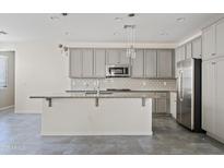 Modern kitchen with gray cabinets, granite counters, and stainless steel appliances at 2241 S Wallrade Ln, Gilbert, AZ 85295