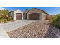Beautiful single-story home featuring a paved driveway, desert landscaping, and a spacious three-car garage at 2856 N Riverdale N Ln, Casa Grande, AZ 85122
