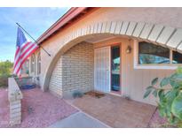Front entry with arched brick details and a tiled patio at 4531 W Aster Dr, Glendale, AZ 85304