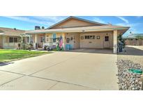 Charming single-story home featuring a large driveway and quaint front porch with a covered carport at 10256 N 105Th Dr, Sun City, AZ 85351