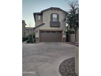 Two-story home showcasing a large driveway, stone accents, and a stylish balcony at 15824 S 12Th Way, Phoenix, AZ 85048
