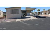 Tan mobile home with covered patio and parking area at 17200 W Bell Rd # 873, Surprise, AZ 85374