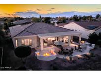 Luxury backyard oasis with a covered patio, fire pit, and outdoor kitchen at 22819 N Del Monte Dr, Sun City West, AZ 85375