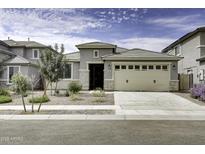 Gray house with beige garage door, landscaping, and a long driveway at 25574 N 164Th Ave, Surprise, AZ 85387