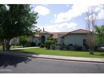 Charming home with a red tile roof, circular driveway and lush, green landscaping at 4119 E Glencove St, Mesa, AZ 85205