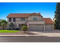Two-story house with tile roof, two-car garage, and landscaped lawn at 5859 E Elmwood E St, Mesa, AZ 85205