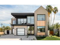 Stunning two-story modern home with a beautiful combination of stucco, brick, and wood accents and a well manicured lawn at 4445 E Roma Ave, Phoenix, AZ 85018
