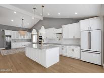 Beautiful kitchen featuring white cabinetry, marble countertops, stainless steel appliances and gorgeous hardwood flooring at 9136 N 81St St, Scottsdale, AZ 85258