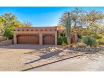 Exterior shot of property, featuring large garage with adobe accents and desert landscaping at 1084 N Boulder Dr, Carefree, AZ 85377