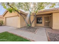 Charming single-story home with mature tree, low maintenance landscaping and two car garage at 1225 E San Angelo Ave, Gilbert, AZ 85234