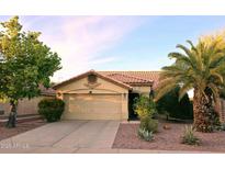 Tan house with tile roof, two-car garage, and desert landscaping at 13830 W Fargo Dr, Surprise, AZ 85374