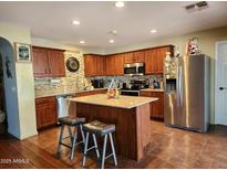 Kitchen with wood cabinets, granite counters, and island at 13830 W Fargo Dr, Surprise, AZ 85374
