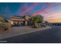 Charming stucco and brick home with desert landscaping, solar panels, and an attached two-car garage at 1808 E Crocus Ave, Queen Creek, AZ 85140