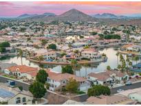 Aerial view of a lakefront community with numerous homes at sunset at 21004 N 53Rd Ave, Glendale, AZ 85308
