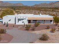 Charming single-story home with a covered front porch, desert landscaping, and mountain views at 10020 W Tortalita Way, Casa Grande, AZ 85194