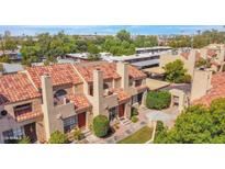 Aerial view of a beautiful home with a red tile roof, mature trees and green landscaping in gated community at 1025 E Highland Ave # 6, Phoenix, AZ 85014