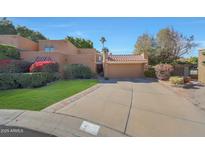 Inviting front exterior showcasing a two-car garage, red tile roof and well-manicured lawn with beautiful shrubbery at 10648 N 11Th St, Phoenix, AZ 85020