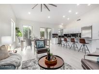 Bright, open concept layout with sleek white kitchen, dining area, and modern furnishings at 15541 E Thistle Dr, Fountain Hills, AZ 85268