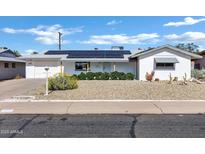 Charming single-story home featuring solar panels, a well-maintained yard, and a single car garage at 5738 E Cicero Rd, Mesa, AZ 85205