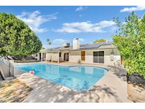 Sparkling pool with solar panels on home in backyard with covered patio, perfect for relaxation and outdoor fun at 7028 N 12Th Way, Phoenix, AZ 85020