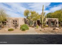 Charming home featuring desert landscaping, a stone facade, and mature trees providing shade and curb appeal at 9626 E Peak View Rd, Scottsdale, AZ 85262