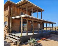 Rustic cabin with a large porch and covered deck showcasing the exterior in a rural setting at 12001 N Allegro Rd, Maricopa, AZ 85139