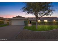 Charming single-story home with a well-manicured front yard and a two-car garage at 12814 W Shadow Hills Dr, Sun City West, AZ 85375