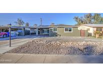 Charming single-story home with desert rock landscaping and covered parking at 3740 E Yale St, Phoenix, AZ 85008