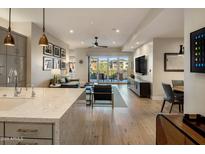 Spacious living room featuring hardwood floors, a balcony, and an open floor plan at 6166 N Scottsdale Rd # A3001, Paradise Valley, AZ 85253