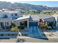 Stunning home showcasing desert landscaping, a blue garage door, and mountain views in the background at 727 E Monte Way, Phoenix, AZ 85042