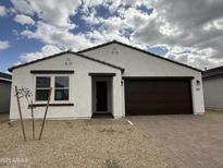 Charming single-story home featuring a well-manicured landscape, brick driveway, and a two-car garage at 9525 W Luxton Ln, Tolleson, AZ 85353