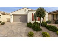 Charming single-story home with a tan facade, a two-car garage, and neat landscaping at 10312 E Tupelo Ave, Mesa, AZ 85212