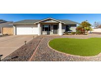 Charming single-story home featuring a well-maintained front yard and a two-car garage at 406 W Riviera Dr, Tempe, AZ 85282