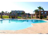 A community pool is surrounded by mature landscaping and overlooks multiple buildings at 4424 E Pueblo Ave, Phoenix, AZ 85040