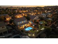 Stunning aerial view of a home with a private pool and lush backyard at dusk at 586 E Stirrup Ln, San Tan Valley, AZ 85143