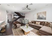 A cozy living room with a plush couch, modern staircase, and stylish decor at 6990 E 6Th St # 1016, Scottsdale, AZ 85251
