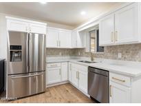 Bright kitchen features white cabinetry, stainless steel appliances, and stylish tile backsplash at 701 W Windsor Ave, Phoenix, AZ 85007
