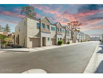 Charming townhomes with attached garages and attractive architectural details against a colorful sky at 8255 N 22Nd Dr, Phoenix, AZ 85021