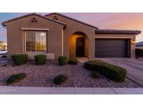 Charming single-story home featuring a desert landscape, arched entry, and a two-car garage at 10309 E Supernova Dr, Mesa, AZ 85212