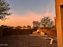 Enjoy this private backyard with desert landscaping and a built-in fireplace to enjoy cool evenings at 23892 W Desert Bloom St, Buckeye, AZ 85326