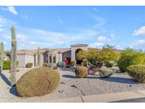 Stunning desert home featuring a stone accent and a meticulously landscaped front yard with mature plants and cacti at 6938 E Lomas Verdes Dr, Scottsdale, AZ 85266